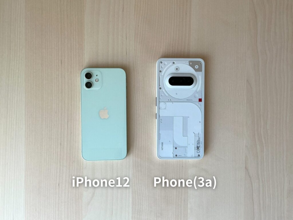 iPhone12とNothingのPhone(3a)を並べて置いてある。Phone(3a)のほうが少し大きい。