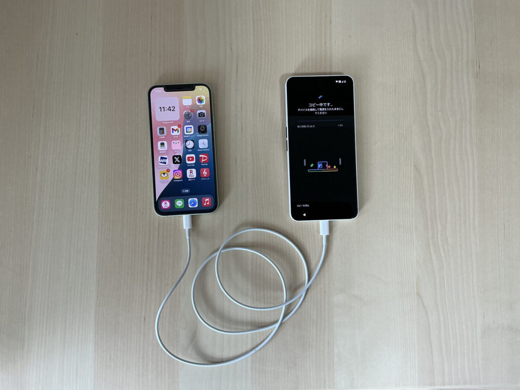 iPhone12からNothingのPhone(3a)に、ケーブルをつないでデータ移行している。