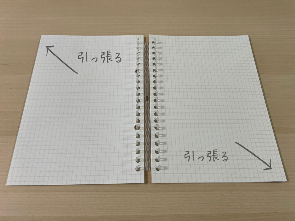 リフィルノートの開け方を示した画像。左側は上方向に、右側は下方向に引っ張ると開く。