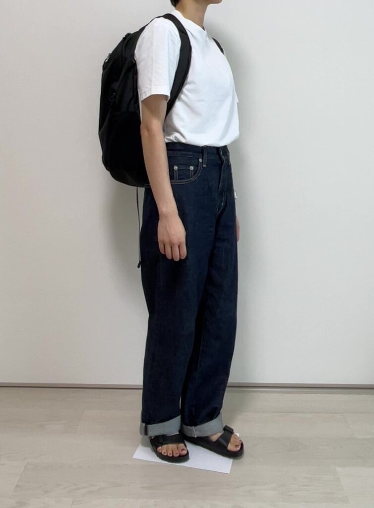 女性が白いTシャツと濃紺のデニムにアリゾナEVAを履いている。