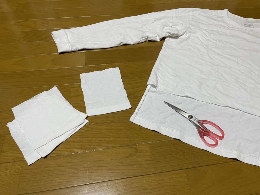 ロンTをハサミで切って、手のひらサイズのクロスを作っている。