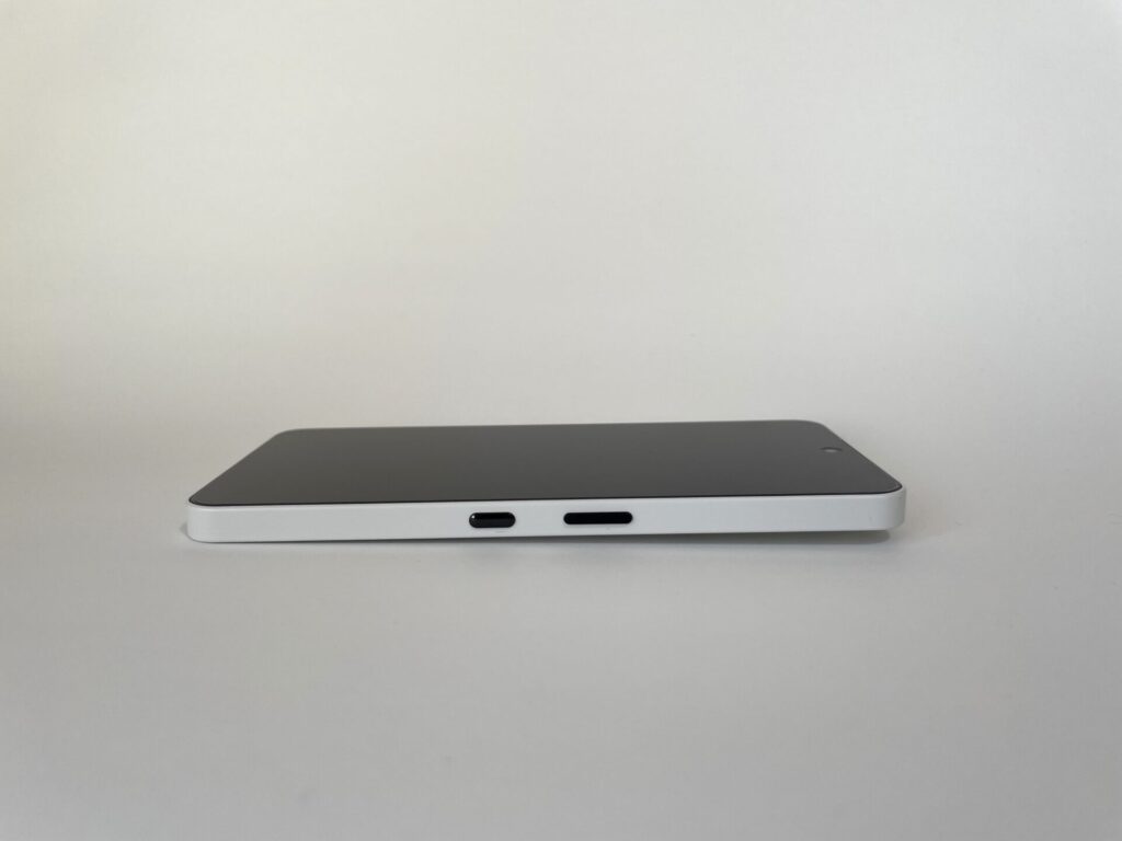 NothingのPhone(3a)を、画面を上にして置いた状態。背面のカメラが出っ張ているので、その分少し斜めになっている。