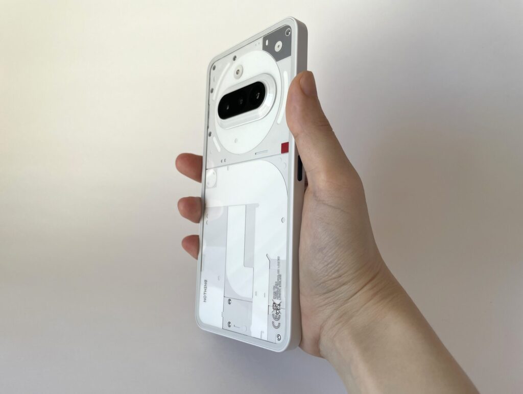 NothingのPhone(3a)を手に持っている。
