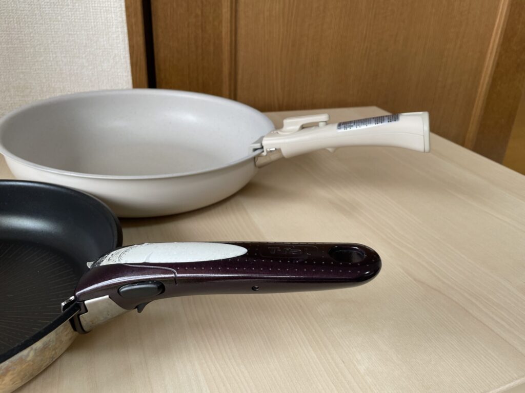 ニトリTORERUの取っ手と、ティファールのフライパンの取っ手が並んでいる。ニトリはくびれた形、ティファールは先にいくほど細くなる形。