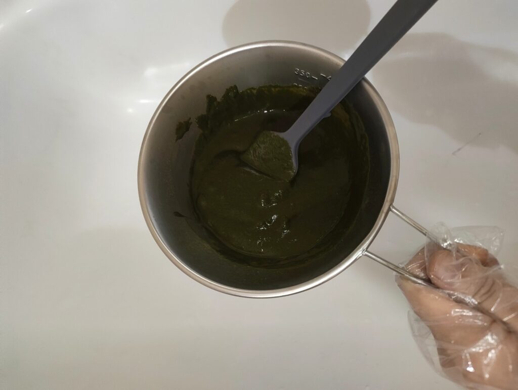 シェラカップの中でヘナと水を混ぜている。