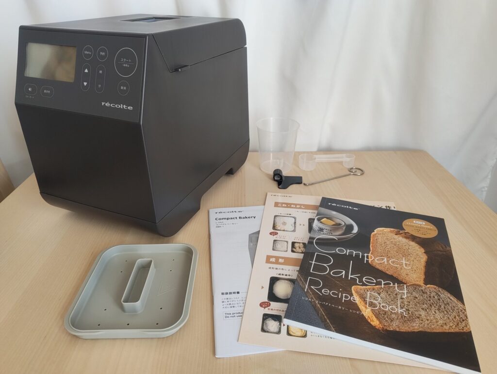 レコルトRBK-1のセット内容。本体、説明書、レシピブック、計量カップ、計量スプーン、餅つき用のフタ、羽取り棒。