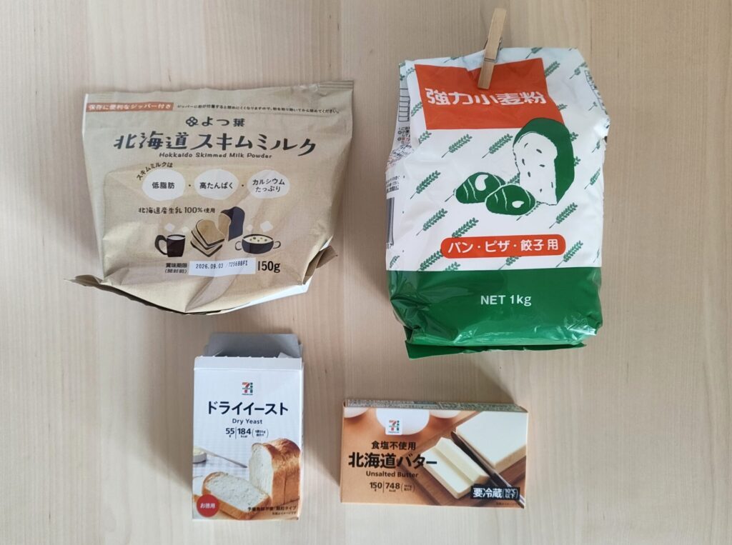 パンの材料の写真。よつば北海道スキムミルク、業務スーパーの強力粉、セブンイレブンのドライイースト、セブンイレブンの無塩バター。